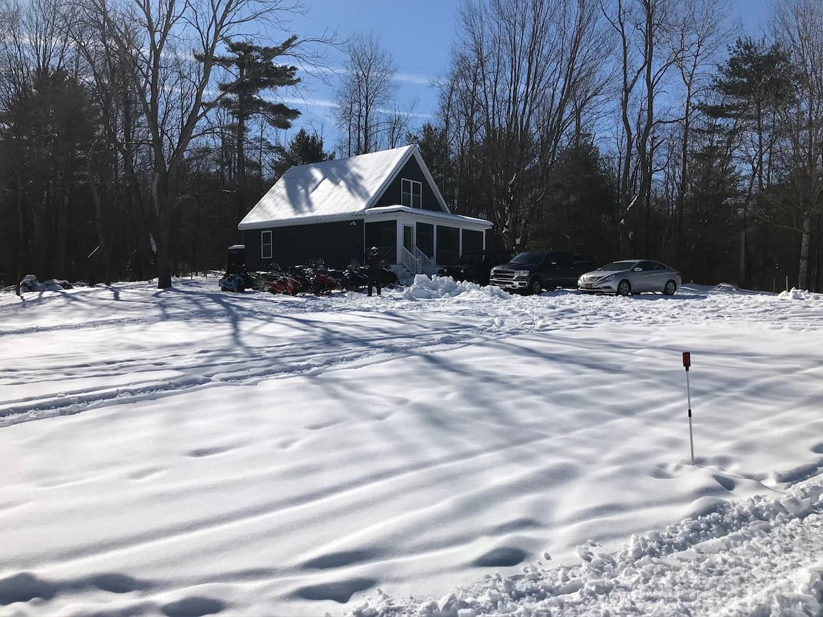 The cottage in winter with snowmobiles